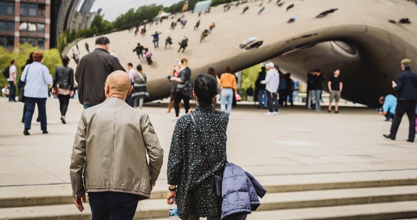 A couple admires the Chicago Cloud Gate from afar