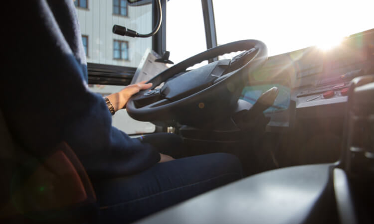 close up of a bus driver's hands on the wheel